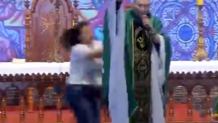 Mujer interrumpe misa y lanza a sacerdote desde el altar
