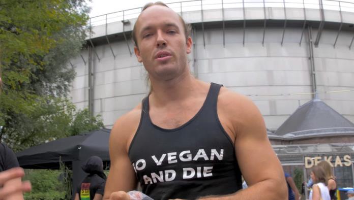 Un hombre come carne cruda en medio de un festival de comida vegana