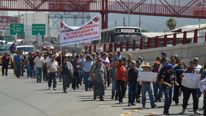 Marchan obreros en apoyo a revisión