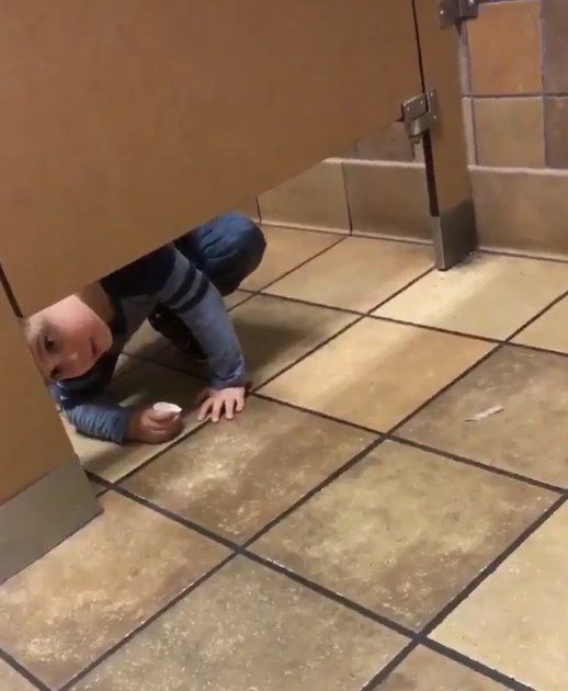 Un niño se arrastra fuera del baño para pedirle ayuda a un extraño