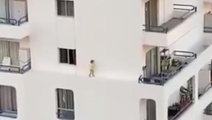 Una niña corre por la cornisa del cuarto piso de un edificio en un despiste de sus padres