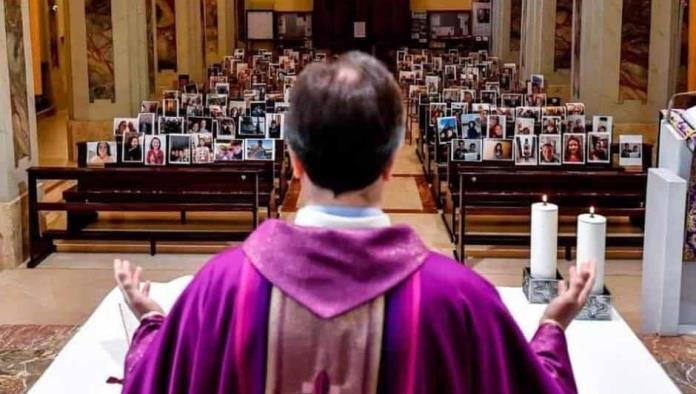 Sacerdote celebra misa con fotografías de fieles