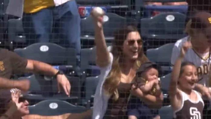 Atrapa pelota de béisbol en el aire mientras cargaba a su bebé
