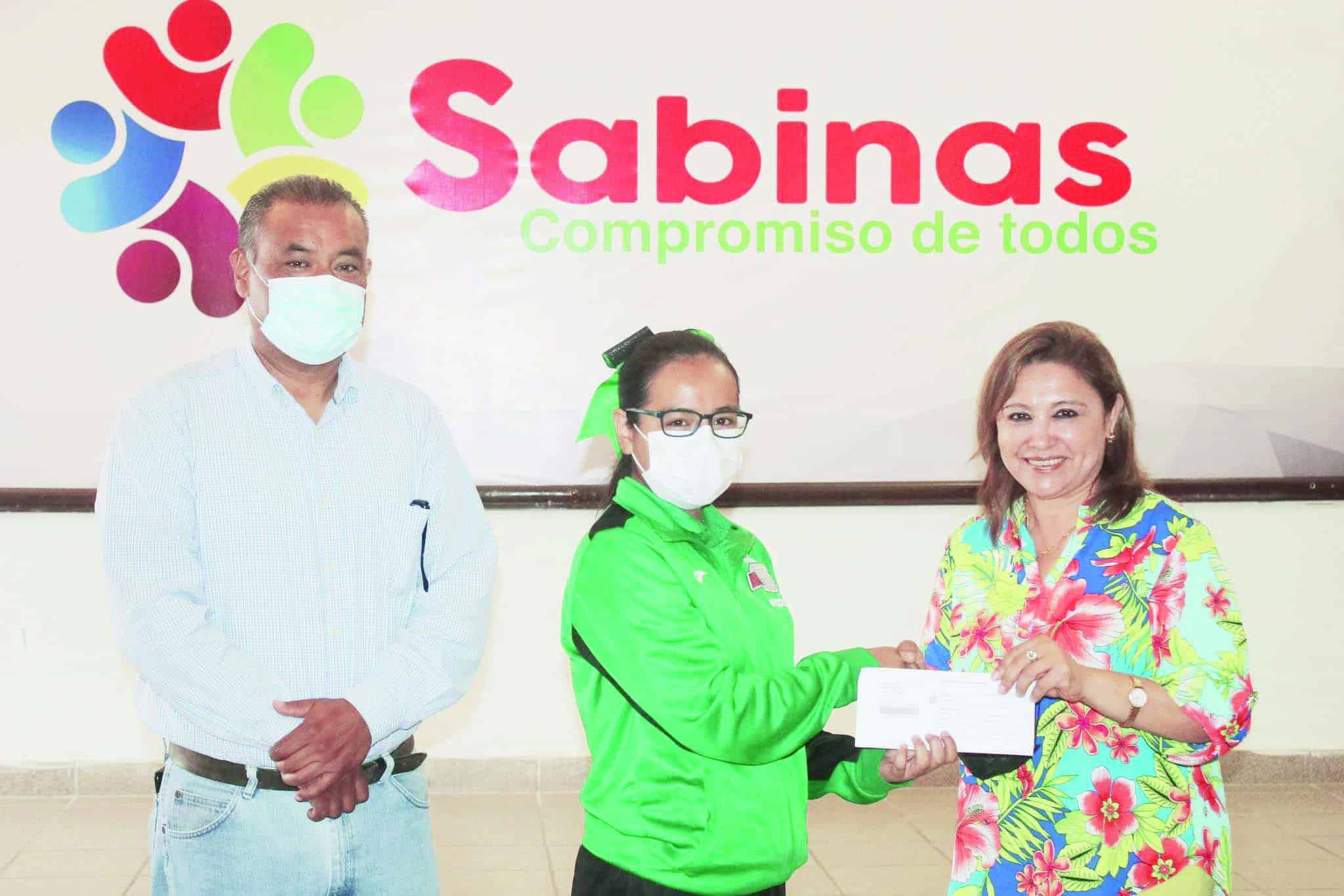 La alcaldesa de Sabinas Diana Haro Martínez entrega las becas.