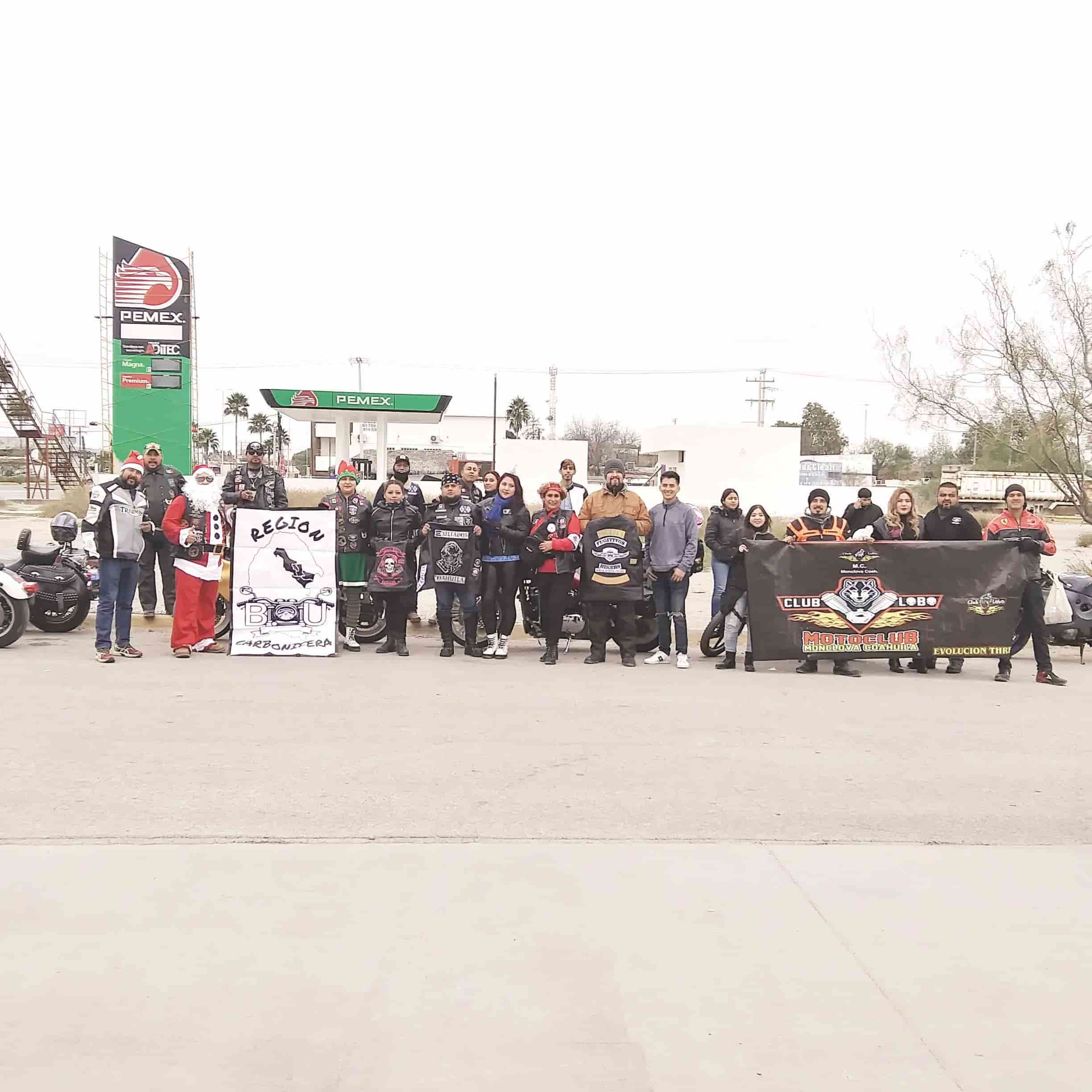 Santa anda entre los motociclistas repartiendo regalos.