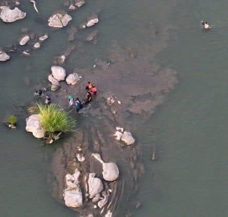 ¡Ver para creer! Con rifle en mano, traficante cruza a migrantes por el río