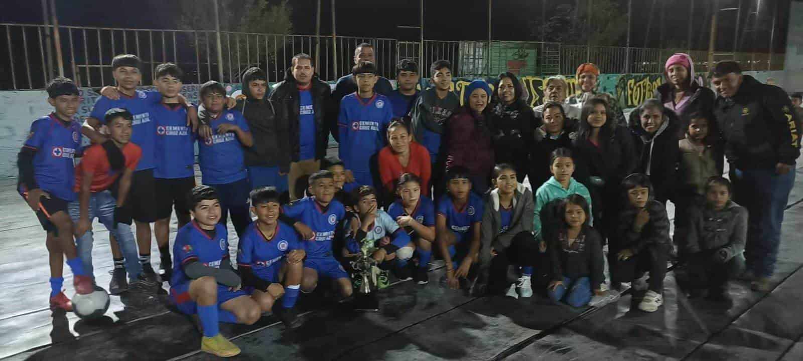 El equipo y porra del equipo Davis Transmisions posando orgullosos con su trofeo de campeones de la infantil mayor.