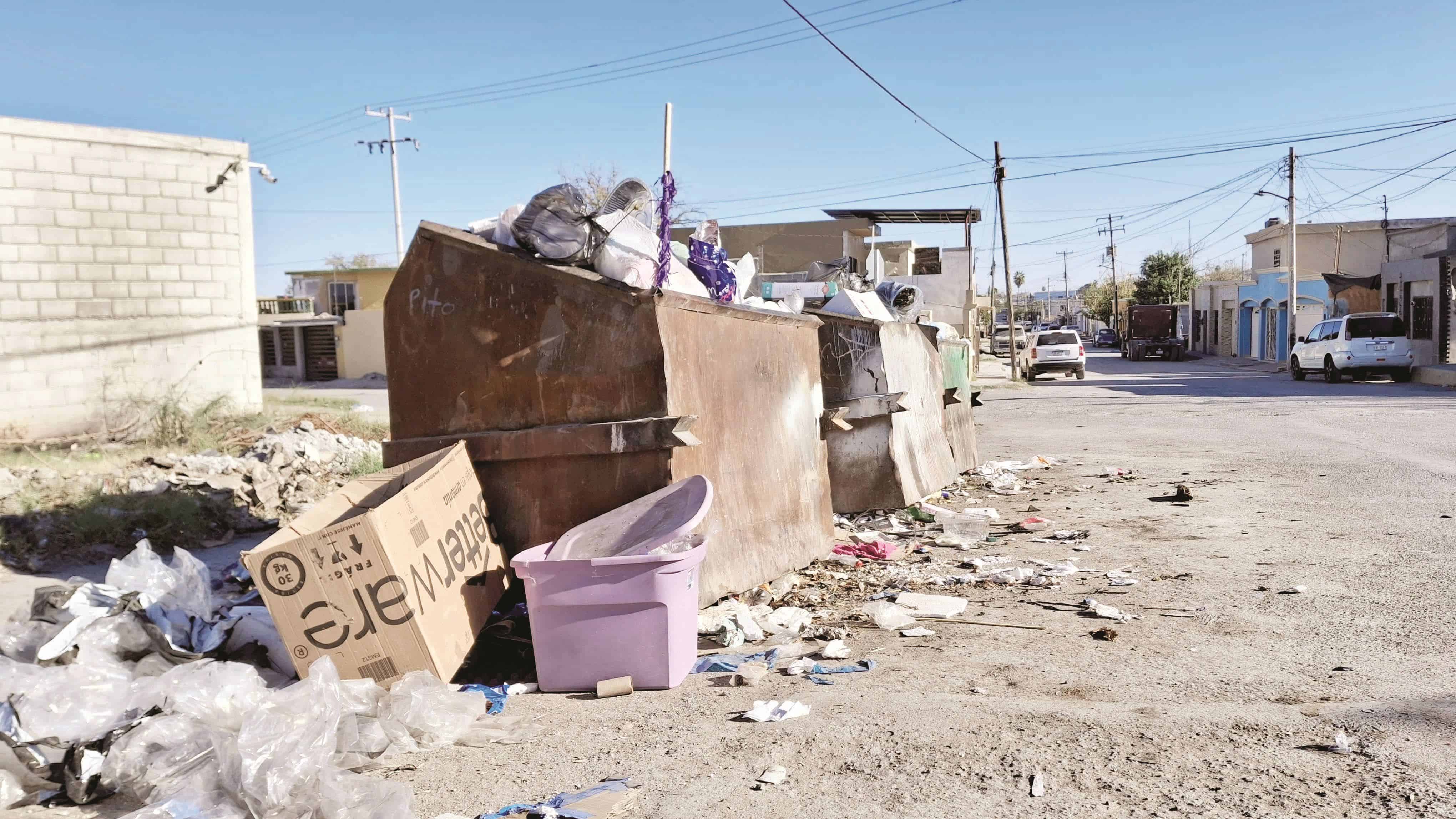 Los contenedores se observan hasta el tope con basura esparcida en los alrededores