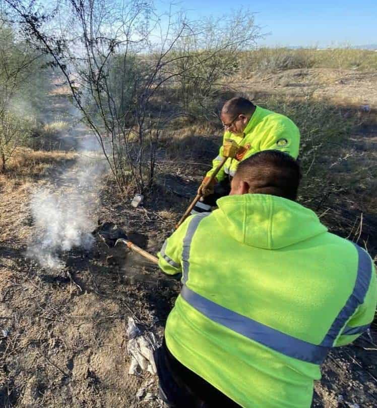 Personal de bomberos sofocan incendio en basurero clandestino en el Barrio 1 de Agujita.