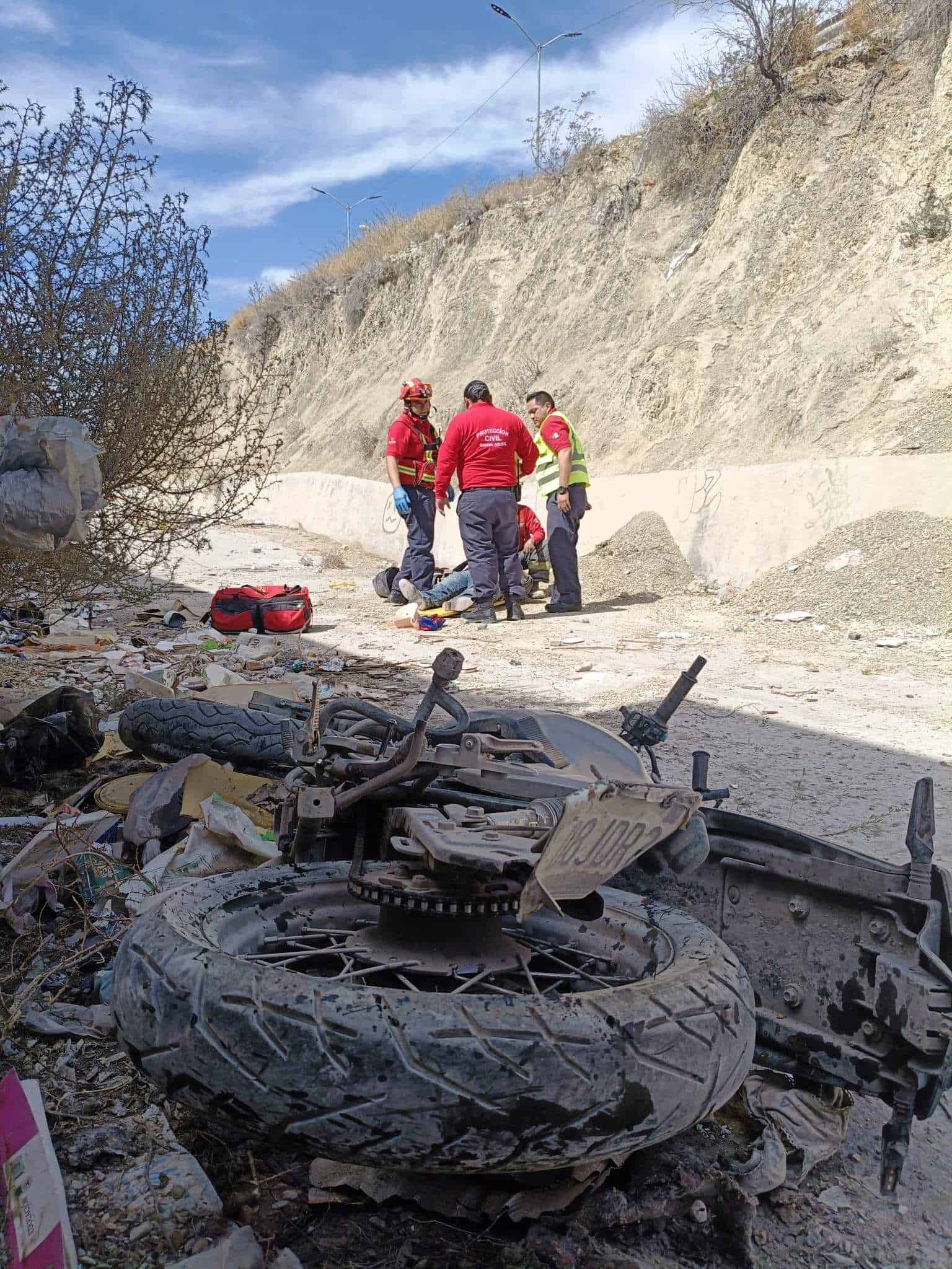 Cae motociclista en canal a más de 15 metros