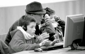 adulto y niños enfrente de computadora